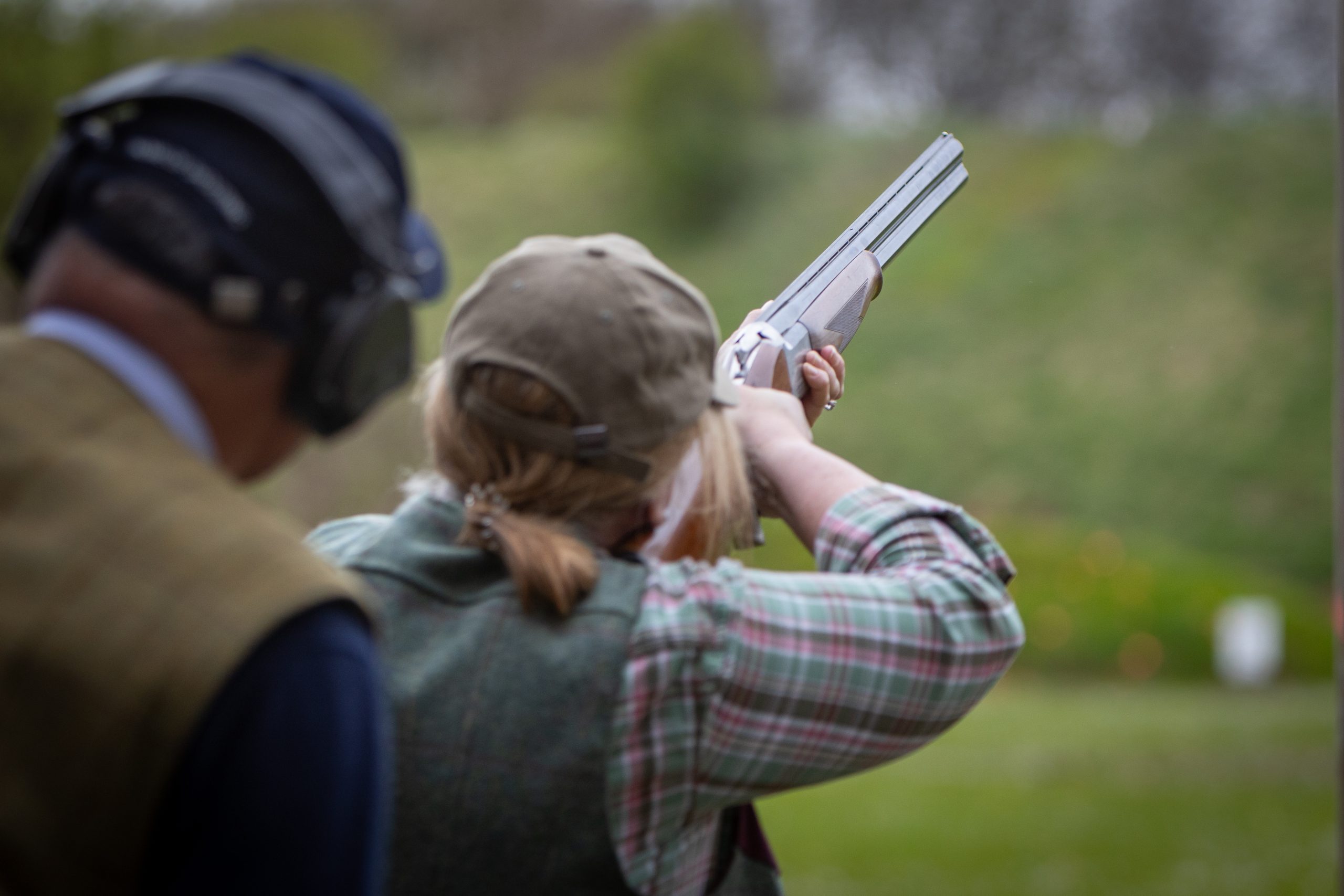 A woman shooting with a coach stood behind her