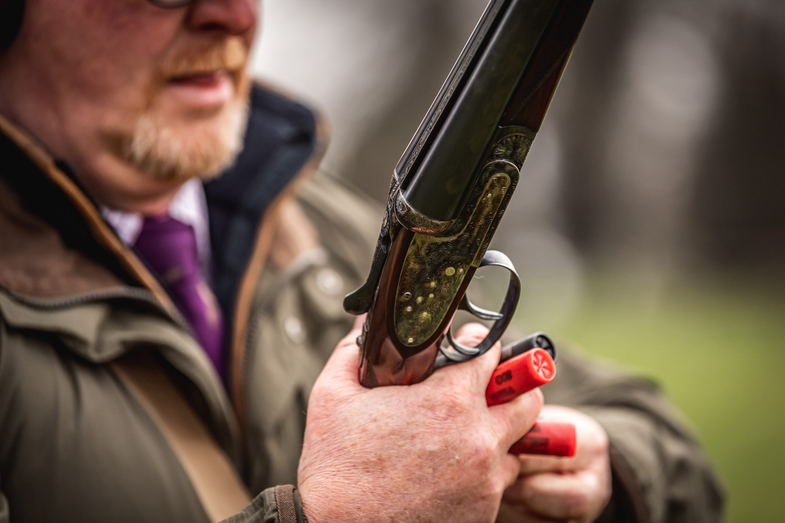 A loader with a gun in his hands and cartridges held in his fingers