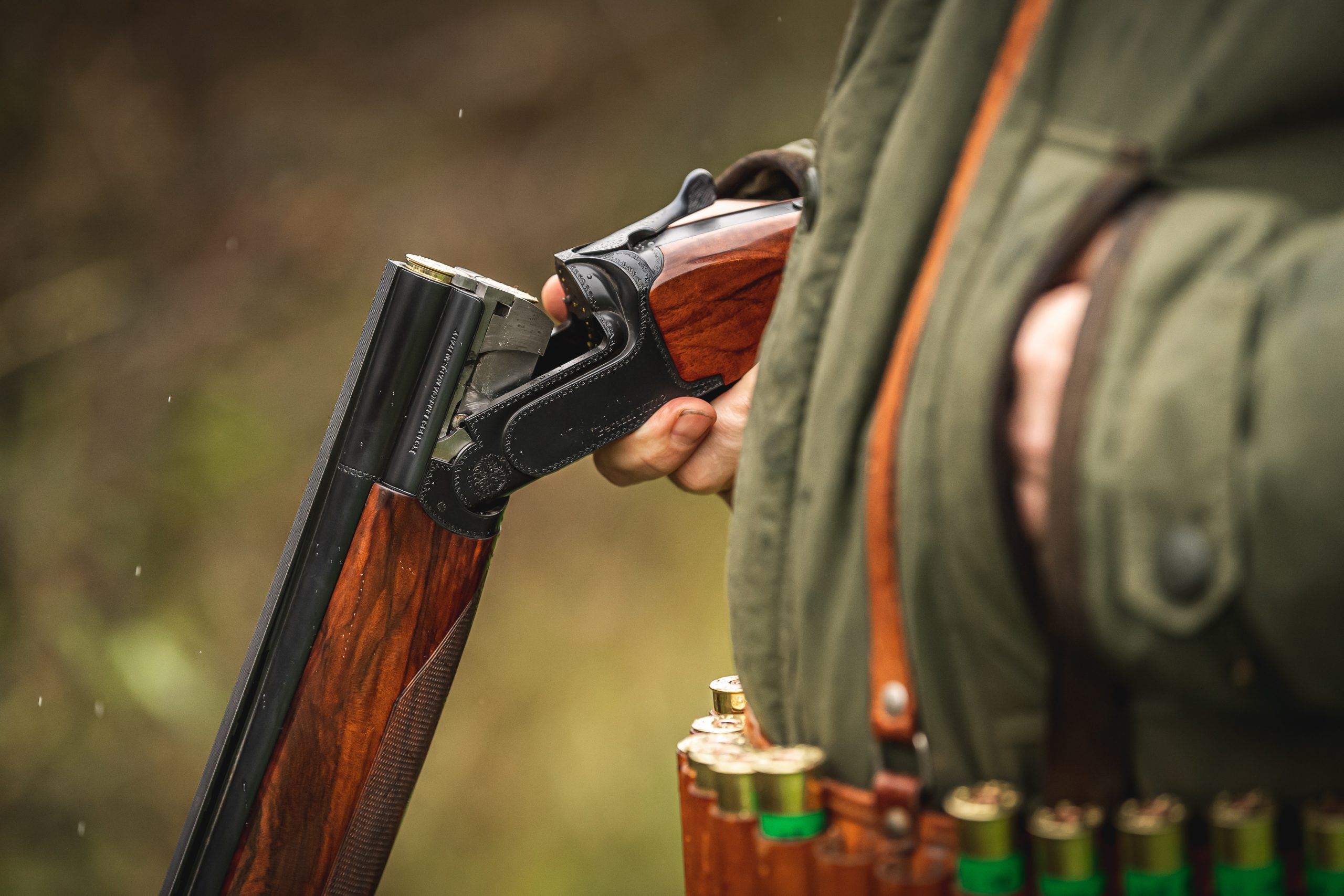 A man waiting with his gun broken with cartridges in the chamber