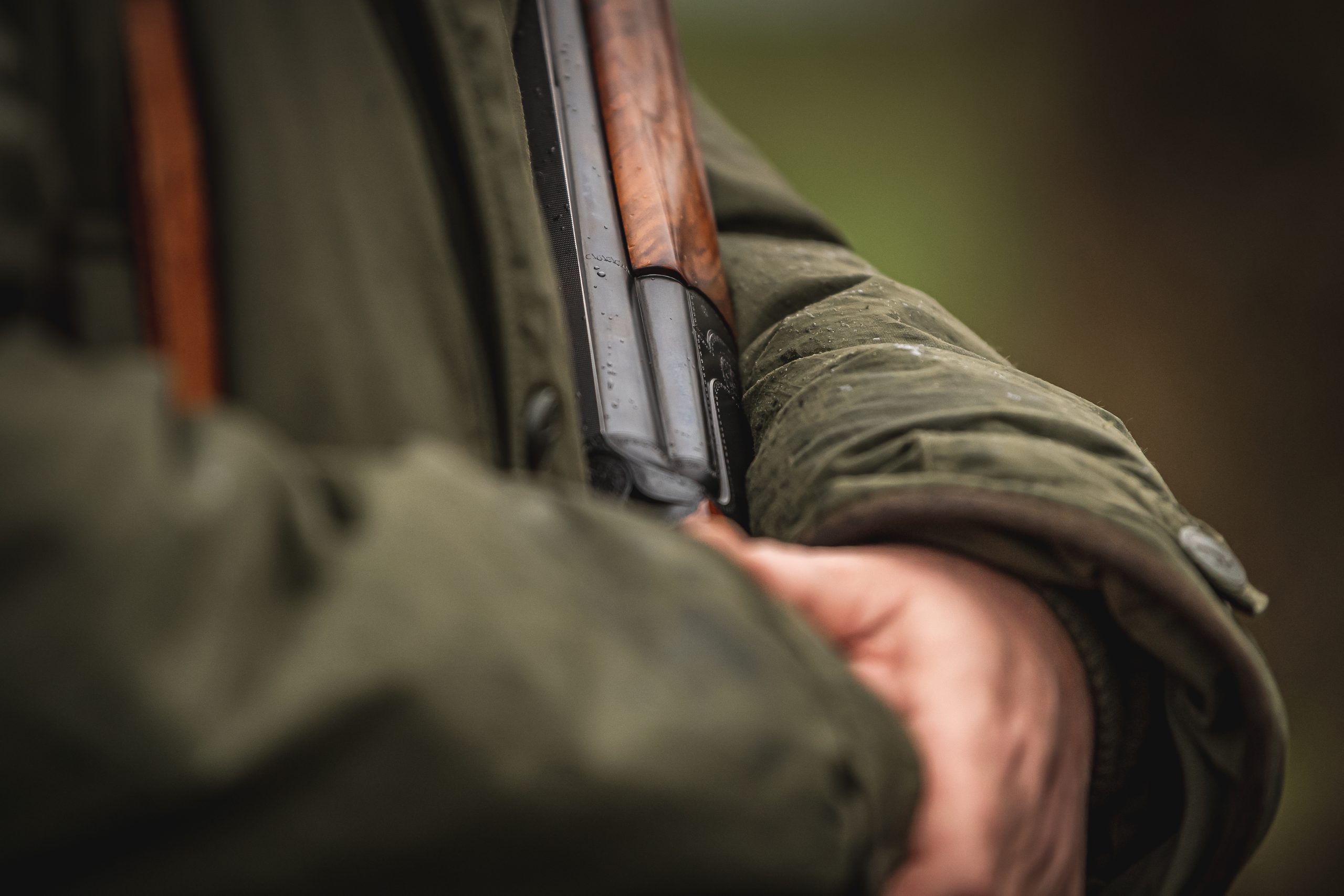 A man cradling a shotgun whilst waiting for birds to come over