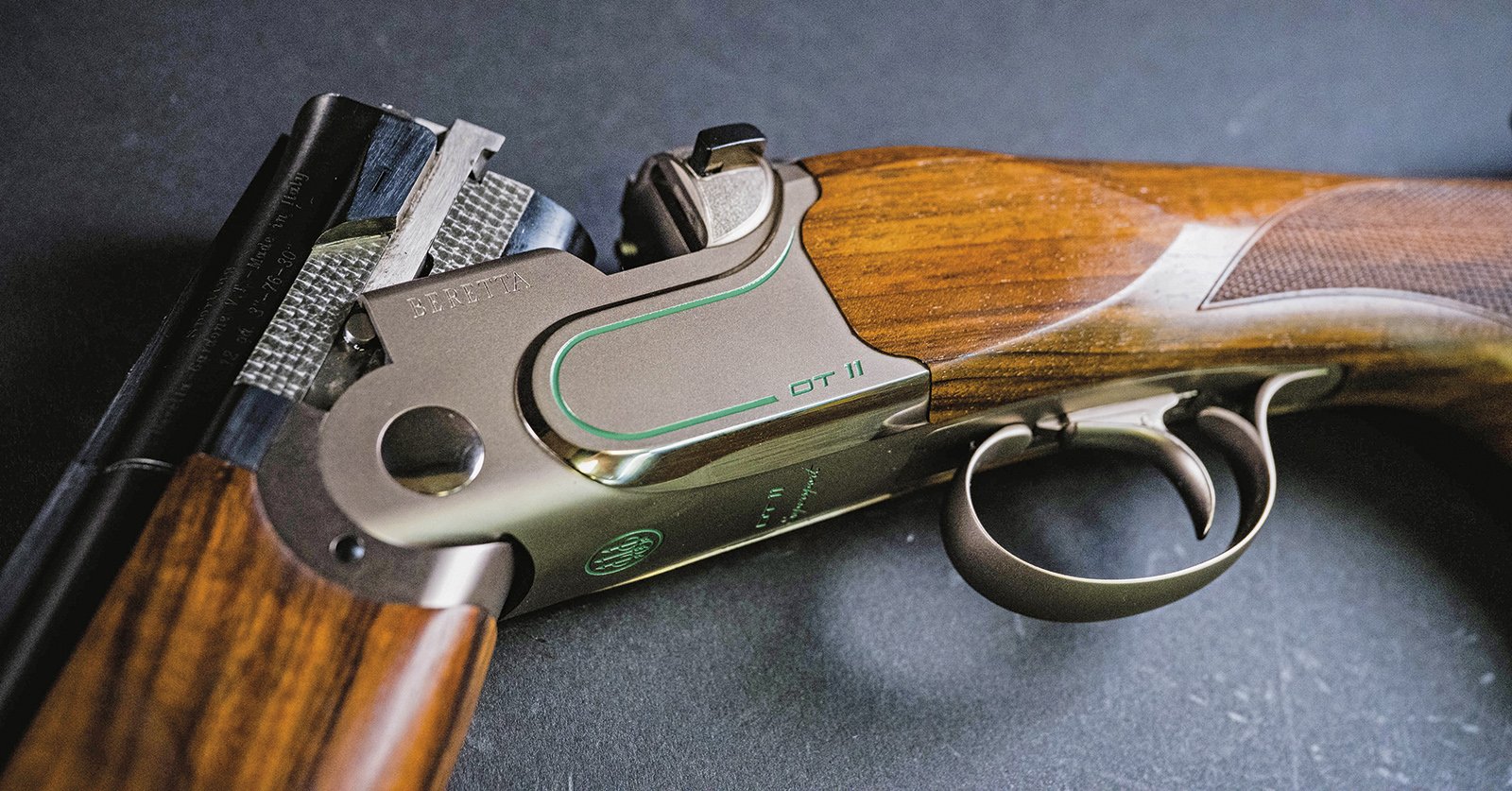 Beretta DT11 Supersport action with green accent and OT11 markings, showing trigger guard and walnut stock