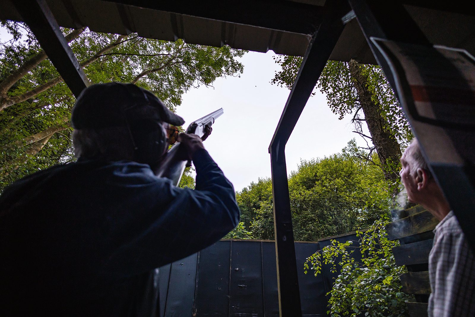 Clay shooter taking aim from a covered Sporting stand at High Lodge in Suffolk