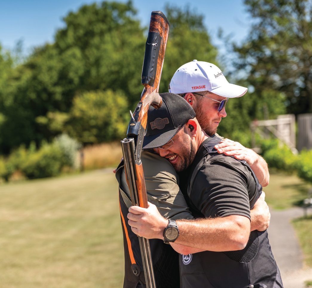 Two shooters embracing at the end of a clay shooting day
