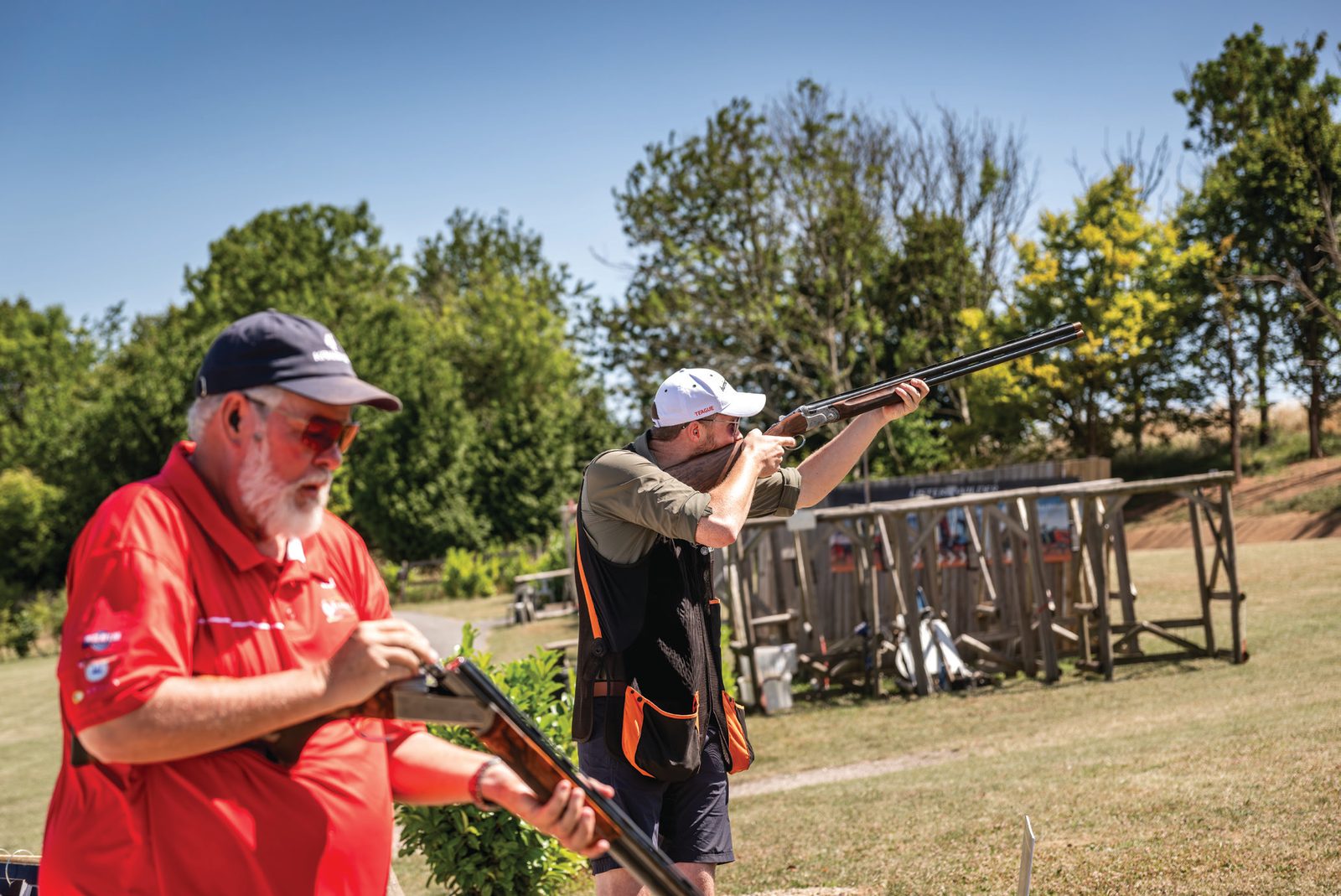 Jonny Carter shooting at a clay competition watched by a referee