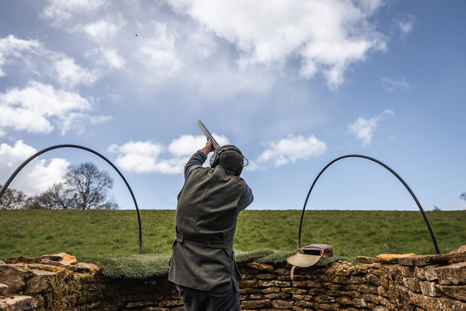 A Gun shooting clays from a stone grouse butt at Great Tew Estate in the Cotswolds